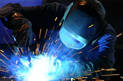 An industrial welder uses an arc welder on a workpiece. An industrial welder uses an arc welder on a workpiece.